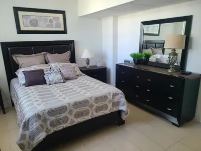a bedroom with a bed and a dresser with a mirror at Lovely condo on the Beach - Tides Hollywood 14th Floor in Hollywood