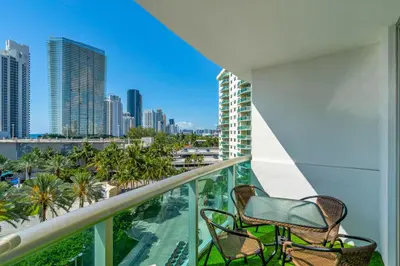 a balcony with two chairs and a view of the city at Resort at Sunny Isles Beach with Ocean view in Sunny Isles Beach