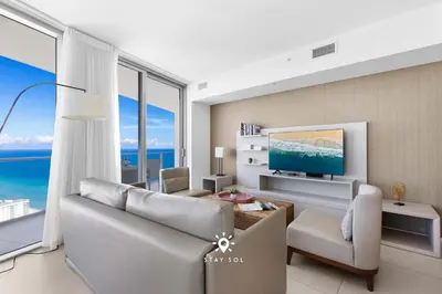a living room with a couch and a tv at Stunning 1BR Apt With Ocean View Balcony in Hollywood