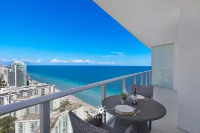 a balcony with a table and a view of the ocean at Stunning 1BR Apt With Ocean View Balcony in Hollywood