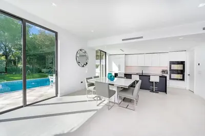 a kitchen and dining room with a table and chairs at Luxe Pool House in North Miami Perfect for Groups in North Miami Beach