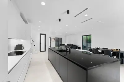 a kitchen with white walls and a black counter top at Absolut Luxe 5 Bed Villa with Pool- Great for Group in North Miami Beach