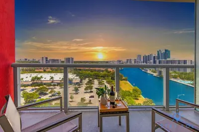 a balcony with a view of a city and the ocean at Coastal Retreat Modern Studio w Harbour Views in Hallandale Beach