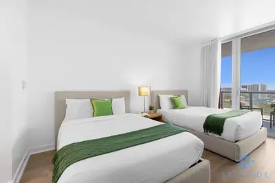 two beds in a room with a window at Coastal Retreat Modern Studio w Harbour Views in Hallandale Beach