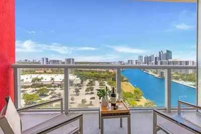 a balcony with a table and chairs and a view of a city at Coastal Retreat Modern Studio w Harbour Views in Hallandale Beach