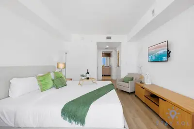 a bedroom with a large bed and a couch at Stylish 1BR High Rise Retreat w Ocean View in Hallandale Beach
