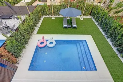 an overhead view of a swimming pool with an umbrella at New Luxe Contemporary Home 4BR-4BA with Heated Pool, Mini Golf, Pool table in Fort Lauderdale