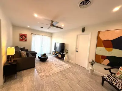 a living room with a couch and a tv at The Pines Hideaway-Your Home Away from Home in Fort Lauderdale