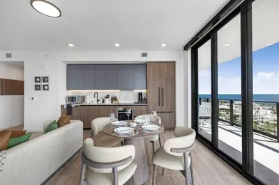 a kitchen and living room with a table and chairs at Ocean Dreams Chic 2BR Getaway Minutes from Miami's Top Attractions in Miami Beach