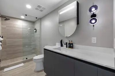 a bathroom with a toilet and a sink and a mirror at Chic Miami Retreat Stylish 2BR Gem for 5 in Miami Beach