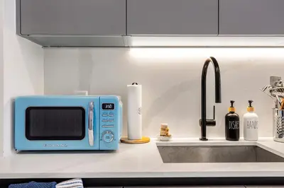 a kitchen counter with a blue microwave and a sink at Chic Miami Retreat Stylish 2BR Gem for 5 in Miami Beach