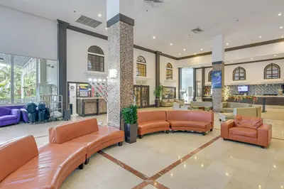 a lobby with couches and chairs in a building at Oceanfront Resort Condo with Gym and Waterfront Pool! in Sunny Isles Beach