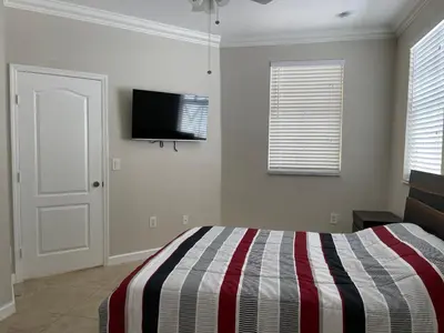 a bedroom with a bed and a tv on the wall at The Garden House in Miami Lakes in Miami Lakes