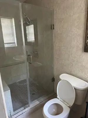 a bathroom with a toilet and a shower with a glass door at Miramar near Hard Rock stadium in Miramar