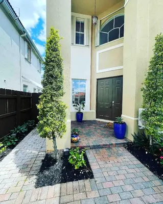 a house with a door and a tree in a courtyard at The Miami Lakes Pool House in Miami Lakes
