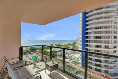 a balcony with a chair and a view of the ocean at Gorgeous Ocean View 3BD Condo in Beachfront Resort 907 in Miami Beach