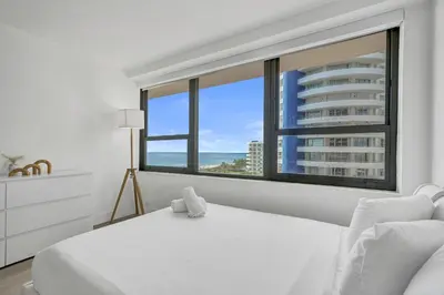 a bedroom with a white bed and a large window at Gorgeous Ocean View 3BD Condo in Beachfront Resort 907 in Miami Beach