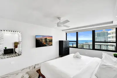 a white bedroom with a bed and a mirror at Luxury Oceanfront Condo 2BR 2.5BA with 700Sqft Terrace Sauna Resort Amenities and Pools 1501 in Miami Beach