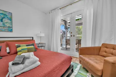 a bedroom with a red bed and a couch at Casa Verde - Wilton Manors - Pool in Fort Lauderdale