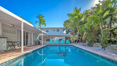 a swimming pool in front of a house with palm trees at Casa Verde - Wilton Manors - Pool in Fort Lauderdale