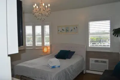 a bedroom with a bed and a chandelier at WATERFRONT STUDIO COZY WITH WATERVIEWs in Miami Beach