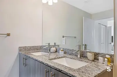 a bathroom with two sinks and a large mirror at Doral 2BD Condo with Skyline Views and Fitness Center in Miami
