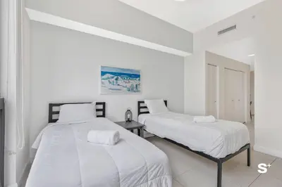 two beds in a room with white walls at Doral 2BD Condo with Skyline Views and Fitness Center in Miami