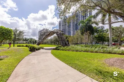 a path through a park with an arch in the middle at Studio Apt in Downtown Doral in Miami