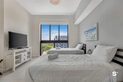 a bedroom with two beds and a flat screen tv at Studio Apt in Downtown Doral in Miami