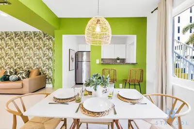 a dining room with green walls and a white table and chairs at 809 Complex in Hollywood