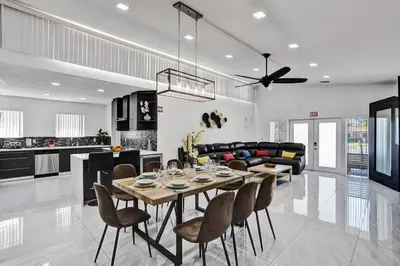 a dining room and living room with a table and chairs at WALK to Hollywood Beach Stylish 5BR and 4BA Villa in Hollywood