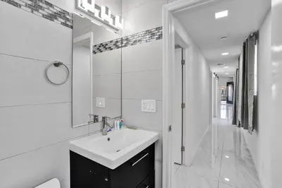 a white bathroom with a sink and a mirror at WALK to Hollywood Beach Stylish 5BR and 4BA Villa in Hollywood