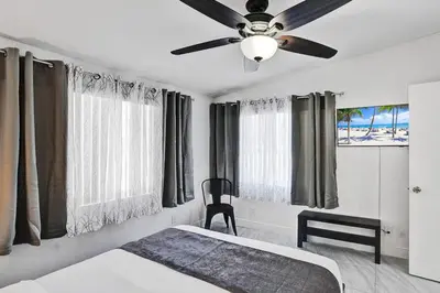 a bedroom with a bed and a ceiling fan at WALK to Hollywood Beach Stylish 5BR and 4BA Villa in Hollywood