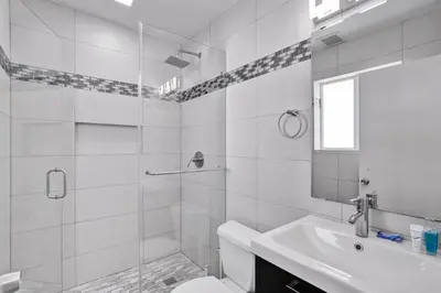 a white bathroom with a toilet and a sink at WALK to Hollywood Beach Stylish 5BR and 4BA Villa in Hollywood
