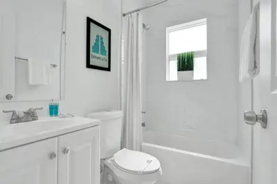 a white bathroom with a toilet and a sink at Palm Breeze Retreat in Hollywood