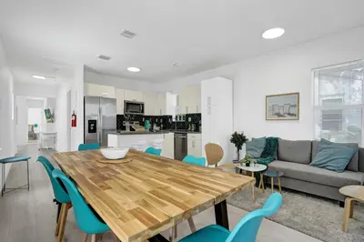 a living room with a wooden table and blue chairs at Palm Breeze Retreat in Hollywood
