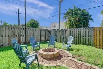 a group of four chairs sitting around a fire pit at Palm Breeze Retreat in Hollywood