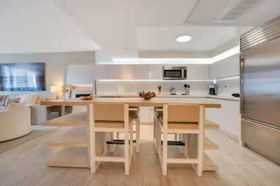 a kitchen with a large wooden table with chairs at Stunning Oceanfront 1BR in the 1 Hotel in Miami Beach
