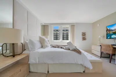 a white bedroom with a white bed and a window at Stunning Oceanfront 1BR in the 1 Hotel in Miami Beach