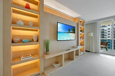 a room with a television on a wall with shelves at Stunning Oceanfront 1BR in the 1 Hotel in Miami Beach