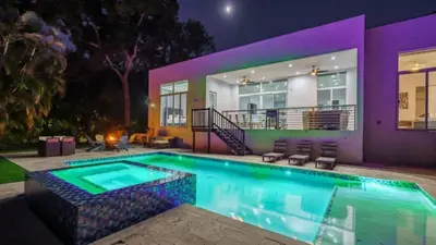 a swimming pool in front of a house at night at Villa Azul Luxe Retreat in Fort Lauderdale