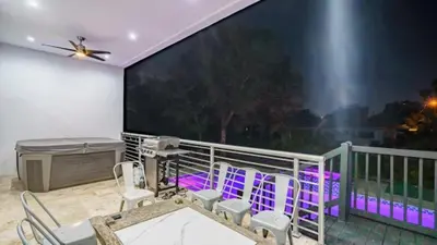 a balcony with purple chairs and a large screen at Villa Azul Luxe Retreat in Fort Lauderdale