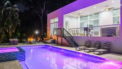 a swimming pool in front of a house at night at Villa Azul Luxe Retreat in Fort Lauderdale