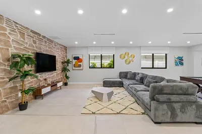 a living room with a couch and a tv at Lakefront Villa Tropical Backy in North Miami Beach