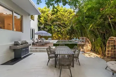 a patio with a table and chairs and a pool at Brand new Luxurious Villa in Hollywood