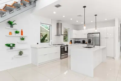 a white kitchen with white cabinets and a sink at One and only New Villa Heated Pool Jacuzzi in Hollywood