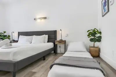 a bedroom with two beds and a plant at St Augustine Hotel By At Mine Hospitality in Miami Beach