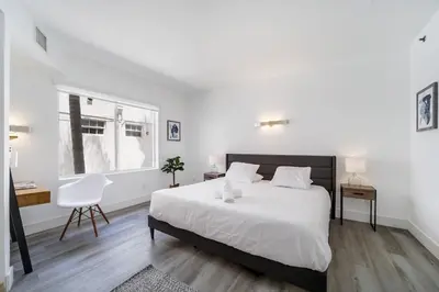 a white bedroom with a large bed and a chair at St Augustine Hotel By At Mine Hospitality in Miami Beach