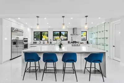 a kitchen with a large island with four blue bar stools at New Construction Villa Top Location Jacuzzi Bkb CT in Miami