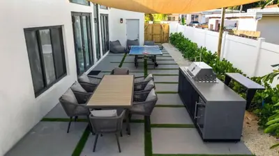 an outdoor patio with tables and chairs and a grill at New Construction Villa Top Location Jacuzzi Bkb CT in Miami